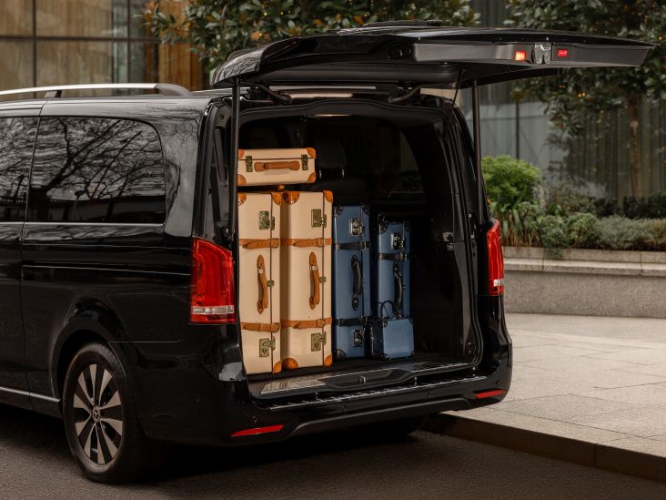 Mercedes-Benz V-Class vehicle with an open trunk filled with five suitcases